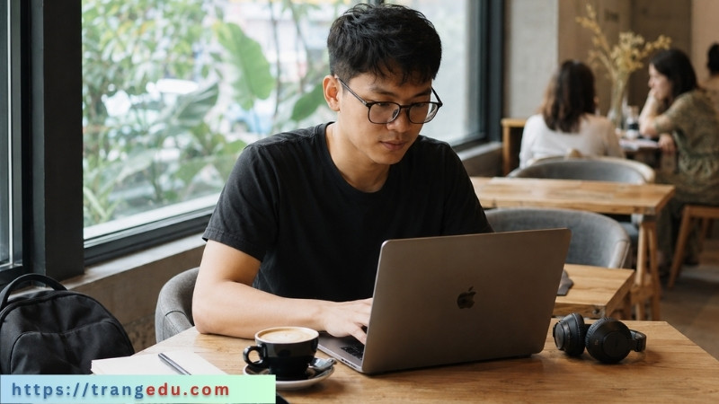 Remote Developer làm việc tự do với laptop trong quán cà phê